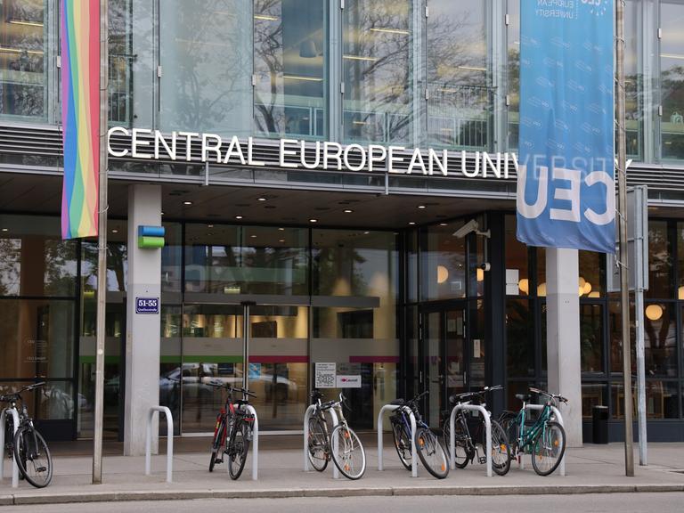 Die Glasfassade des Eingangs der Central European University in Wien, davor stehen Fahrräder.