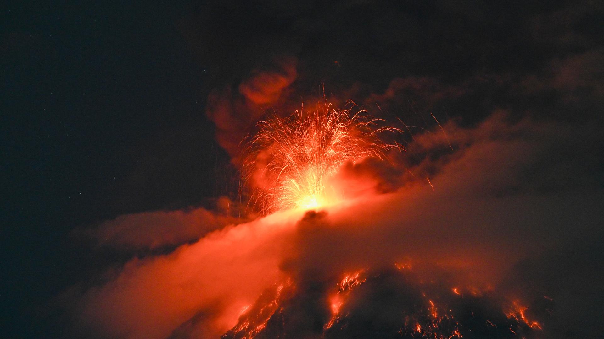 Der Vulkan Fuego speit in der Nacht Lava und Feuerfunken in die Luft. Der Vulkan Fuego speit in der Nacht Lava und Feuerfunken in die Luft.