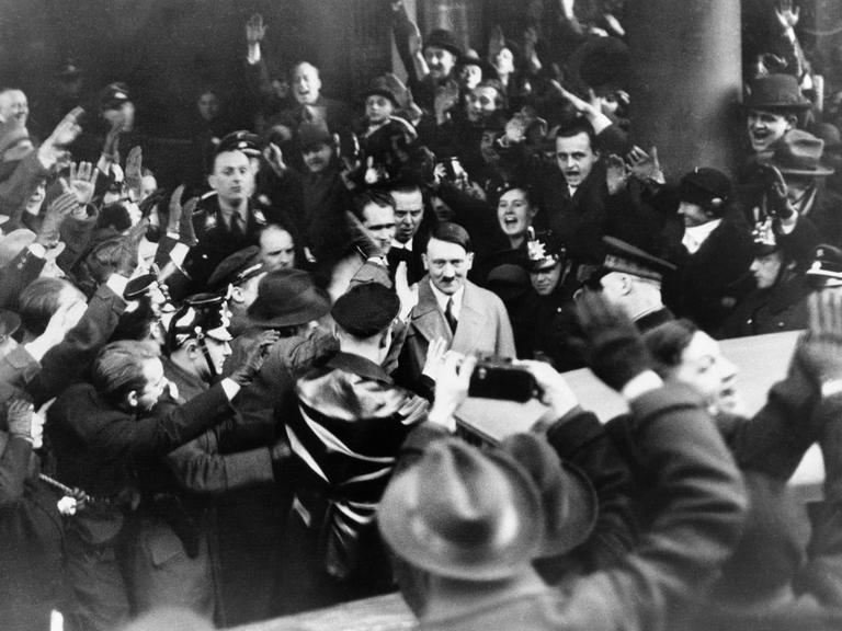 Followers of the Nationalist Socialist Party cheer their leader Adolf Hitler, as he left the Hotel Kaiserhof in Berlin, Jan. 30, 1933 following his appointment by President Von Hindenburg as Chancellor of Germany. The Nazi chieftain returns their Fascist salute. (AP Photo)
