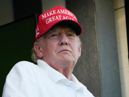 Der frühere US-Präsident Donald Trump trägt bei einem Golf-Spiel eine rote Baseball-Kappe mit der Aufschrift "Make America great again".