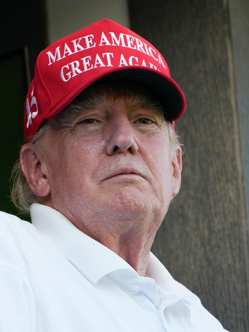 Der frühere US-Präsident Donald Trump trägt bei einem Golf-Spiel eine rote Baseball-Kappe mit der Aufschrift "Make America great again".