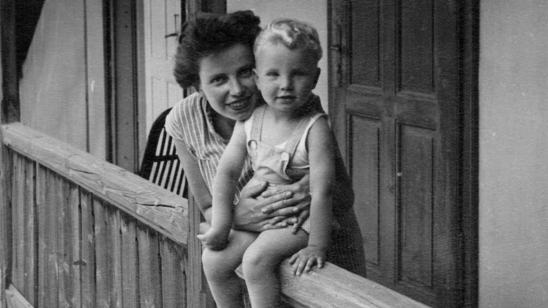 Schwarzweißaufnahme einer Mutter mit Sohn auf einem Balkon