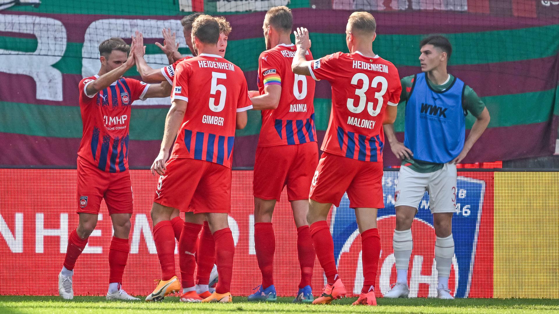 Zu sehen sind mehrere Spieler des 1. FC Heidenheim während der Partie gegen Augsburg. Sie freuen sich nach einem Treffer ins gegnerische Tor. Zu sehen sind mehrere Spieler des 1. FC Heidenheim während der Partie gegen Augsburg. Sie freuen sich nach einem Treffer ins gegnerische Tor.