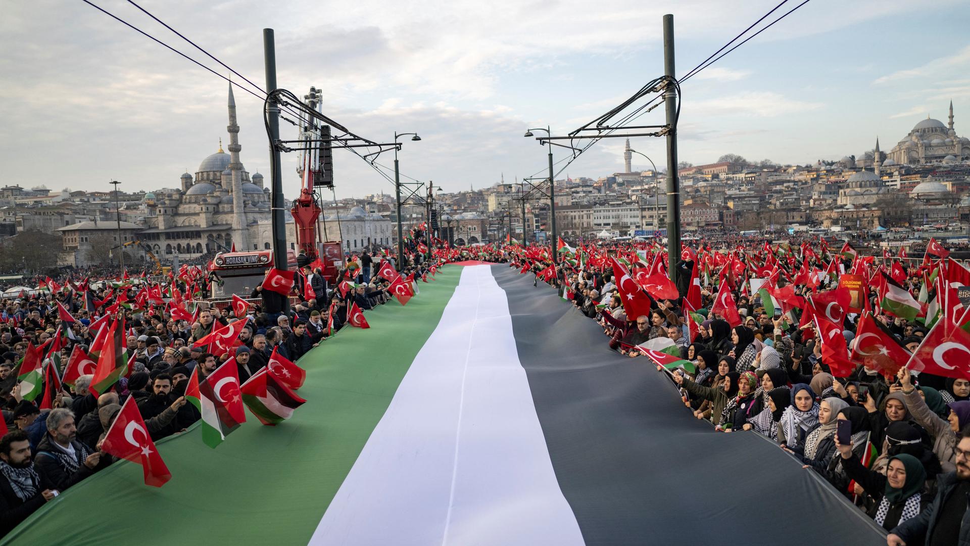 Tausende demonstrieren auf der Galata-Brücke in Istanbul mit einer riesigen palästinensischen Flagge. Tausende demonstrieren auf der Galata-Brücke in Istanbul mit einer riesigen palästinensischen Flagge.