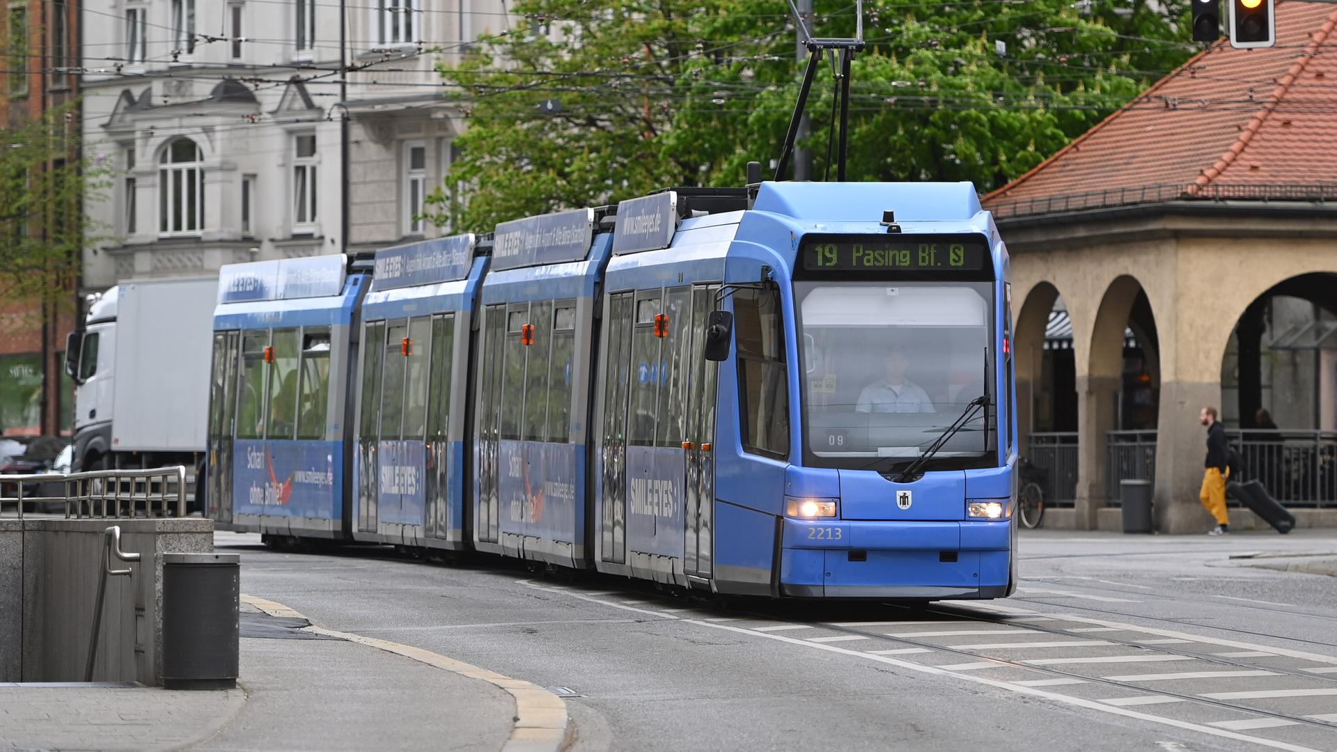 Eine blaue Straßenbahn fährt durch eine Stadt. Eine blaue Straßenbahn fährt durch eine Stadt.