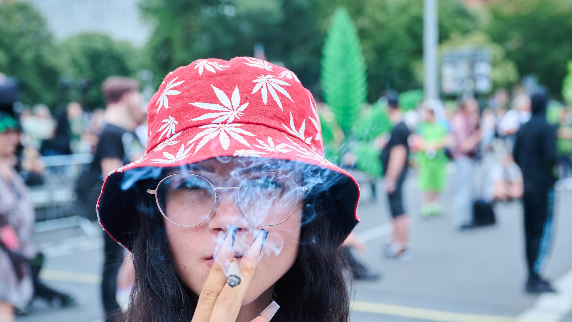 Die Teilnehmerin einer Demonstration für die Cannabis-Legalisierung raucht einen Joint auf der Hanfparade, die laut Angaben der Veranstalter die größte Demonstration für Cannabis in Deutschland ist