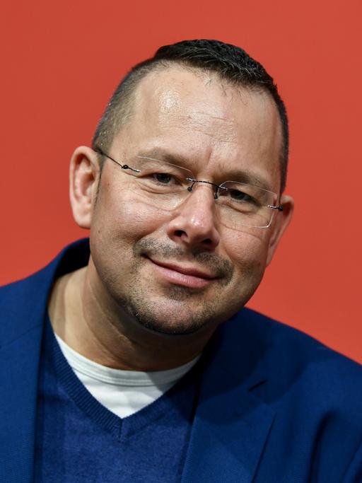 Der Autor Marko Martin, randlose Brille, kurzes Haar, dunkelblaues Sacko, lächelt in die Kamera.