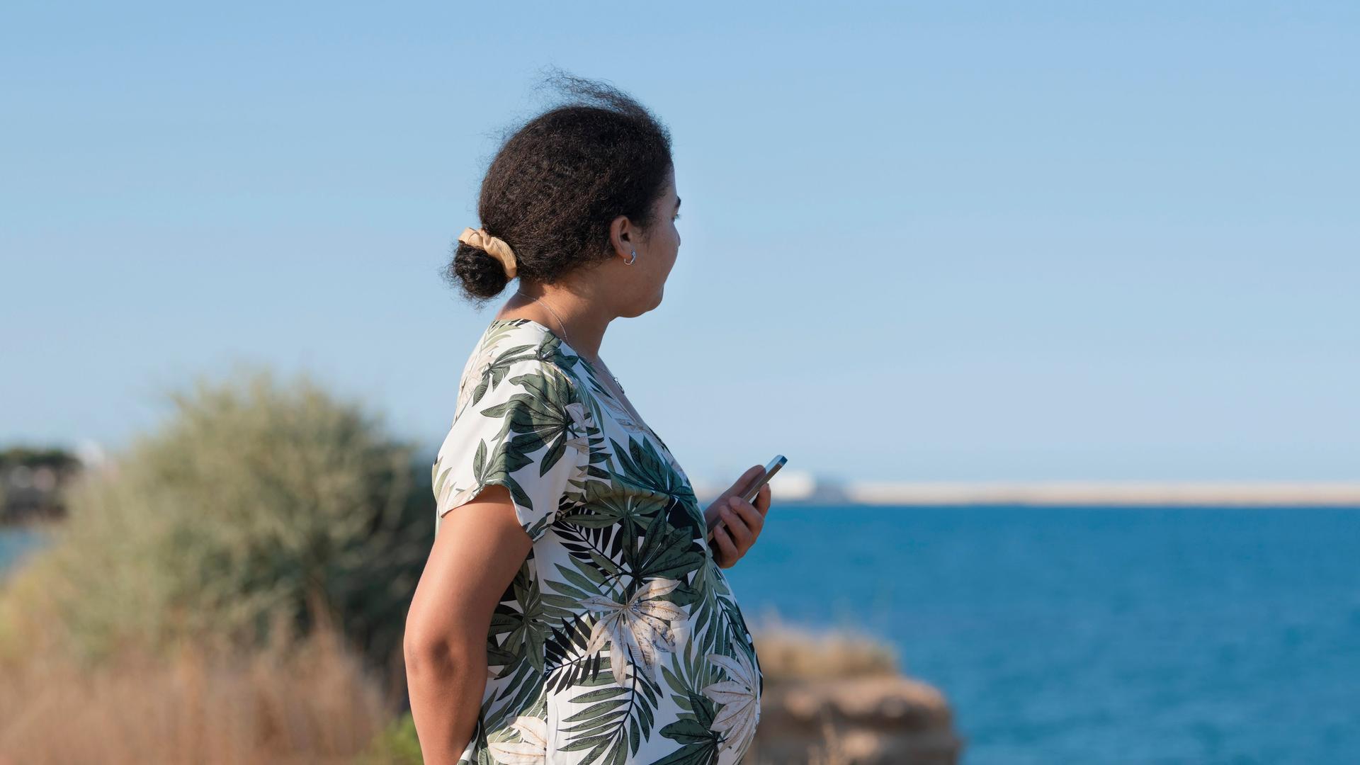 Seitenansicht einer schwangeren Frau am Meer. (Symbolfoto)