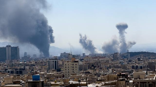 Über sehr vielen Häusern sind mehrere große Rauchwolken zu sehen, die in den Himmel aufsteigen.