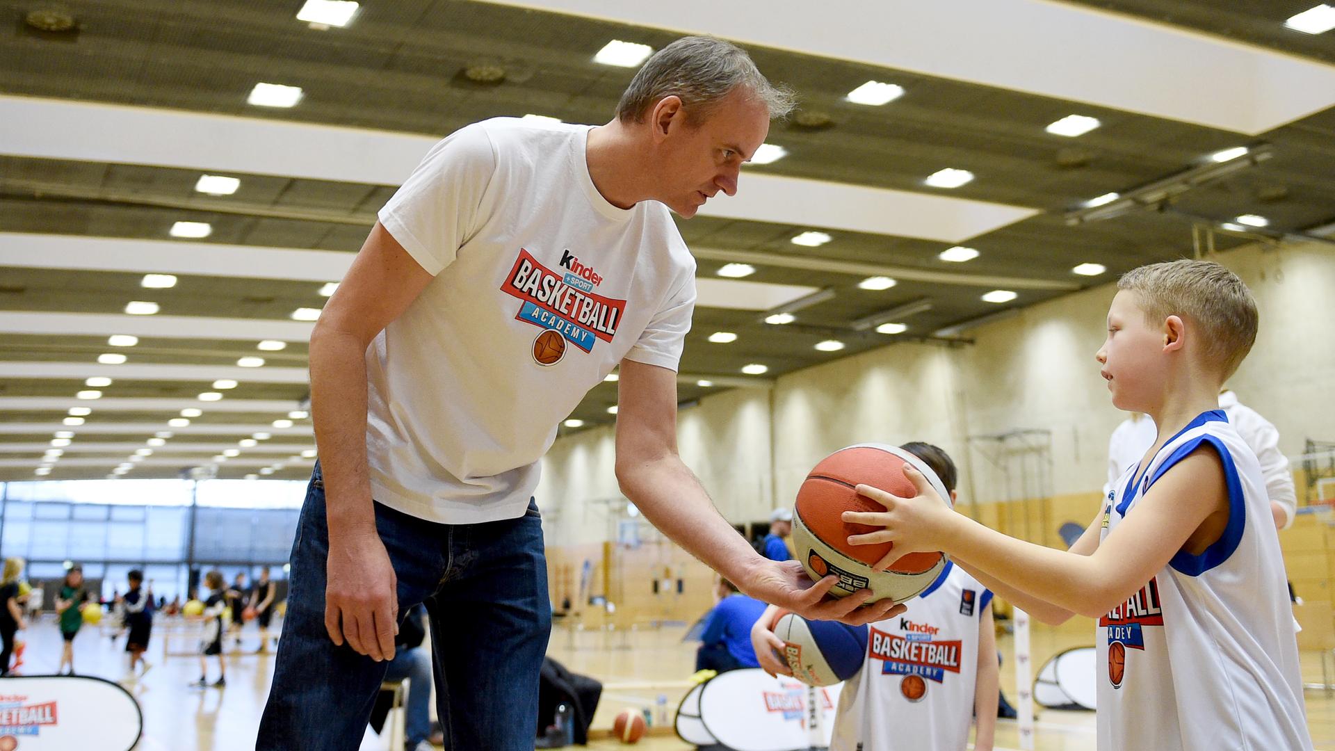 Henning Harnisch gibt am 18.2.2017 auf einem Parcours der «kinder+Sport Basketball Academy» in der Max-Schmeling-Halle in Berlin einem Kind einen Ball. 