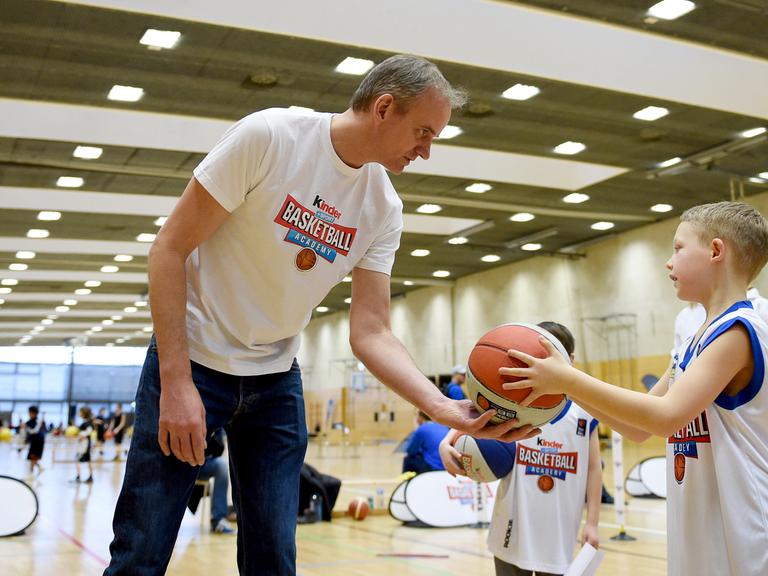Henning Harnisch gibt am 18.2.2017 auf einem Parcours der «kinder+Sport Basketball Academy» in der Max-Schmeling-Halle in Berlin einem Kind einen Ball. 