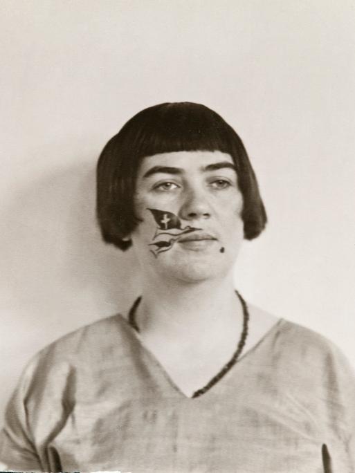 Schwarz-Weiß-Fotografie der Kölner Dadaistin Marta Hegemann mit Pagenschnitt und einer Zeichnung im Gesicht.