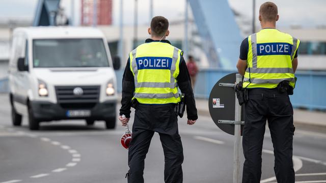 Zwei Polizisten stehen an der deutsch-polnischen Grenze. 