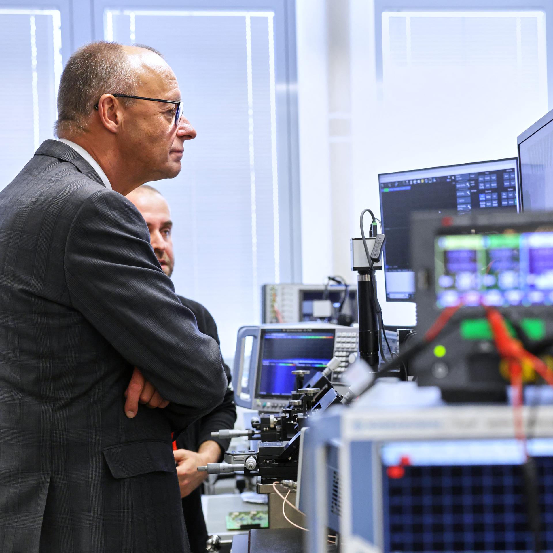 Friedrich Merz besichtigt ein sogenanntes Hochfrequenz-Labor und schaut auf eine größere Anzahl an elektronischen Geräten.