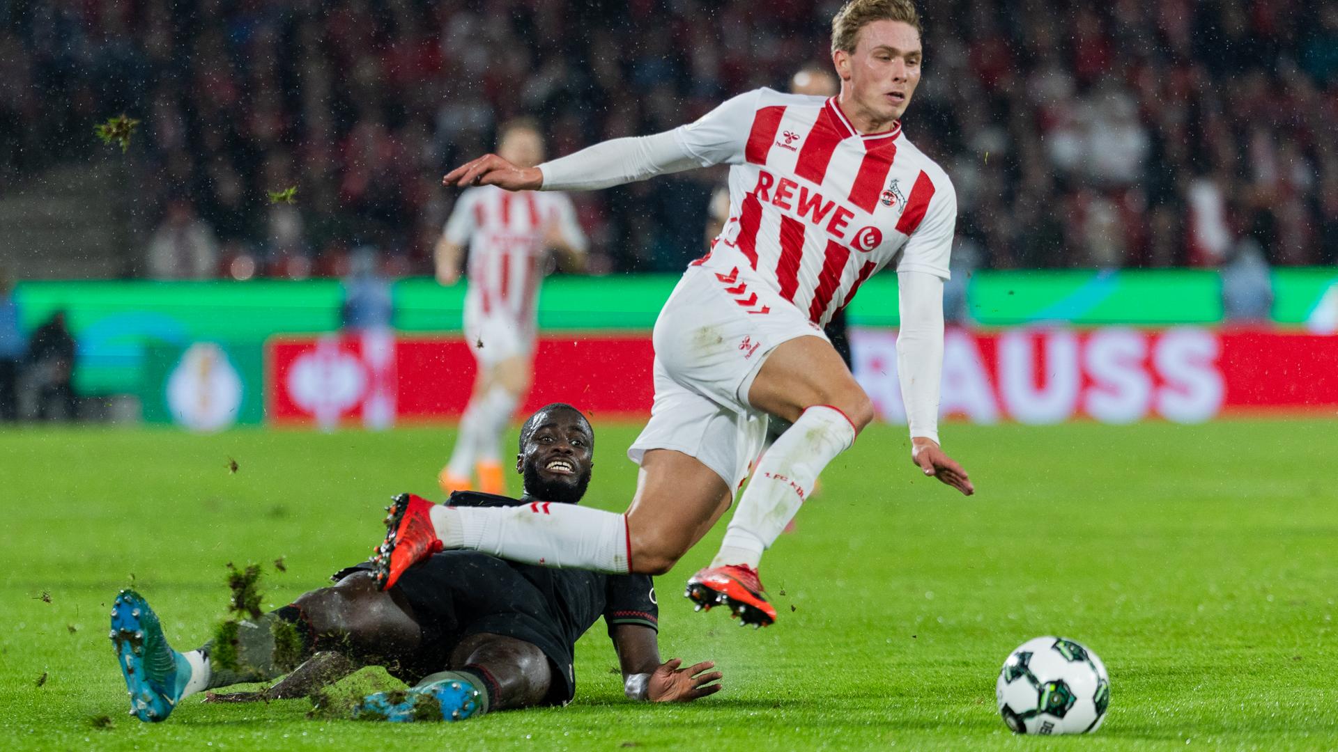 Kölns Sebastian Sebulonsen (r) und Münchens Oswald Upamecano versuchen an den Ball zu kommen.  Kölns Sebastian Sebulonsen (r) und Münchens Oswald Upamecano versuchen an den Ball zu kommen.