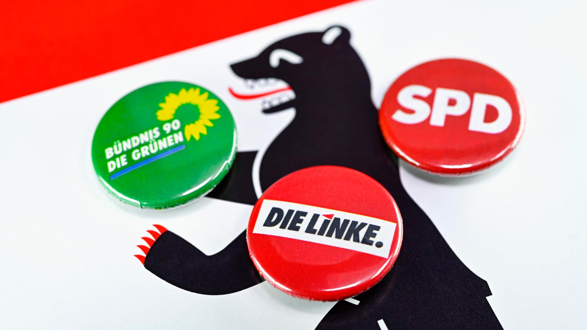 Parteianstecker von Die Linke, SPD und Die Grünen auf dem Wappen von Berlin