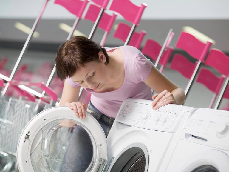 Eine junge Frau sucht eine Waschmaschine aus in der Shopping Mall von Woronesch.