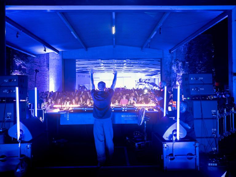 DJ Alle Farben hebt die Hände in die Höhe und heizt dem Publikum ein. Bei einer besonderen Party zum 150-jährigen Jubiläum der Bayreuther Festspiele hat der DJ Motive aus Wagners klassischen Werken in seine elektronischen Live-Sets einfließen lassen.