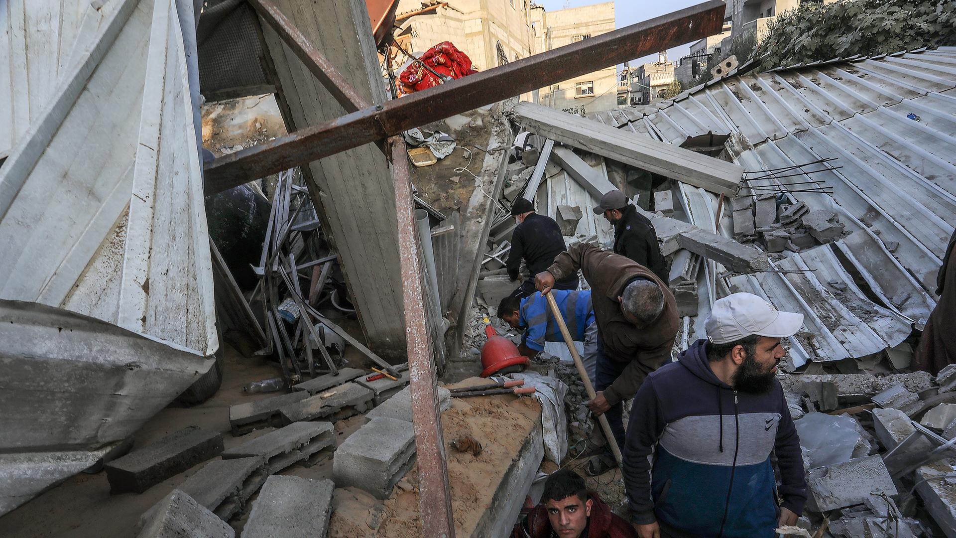Menschen zwischen zerstörten Gebäuden in Rafah im Gazastreifen