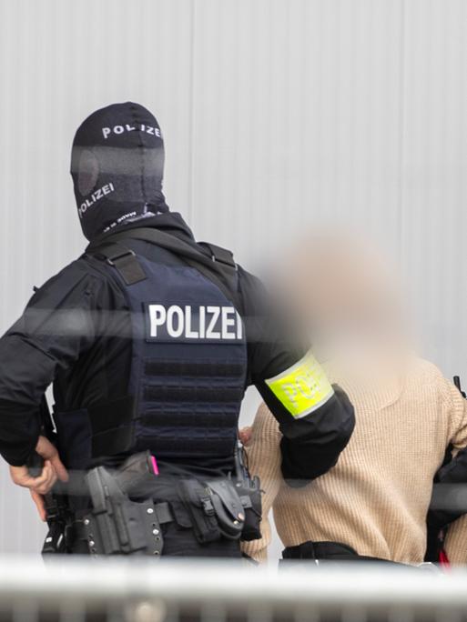 Frankfurt/Main: Polizei-Spezialeinsatzkräfte führen eine Angeklagte in das provisorische Gerichtsgebäude in der Außenstelle Sossenheim des Oberlandesgericht Frankfurt, in dem der Prozess gegen die mutmaßliche "Reichsbürger"-Gruppe um Prinz Reuß stattfindet