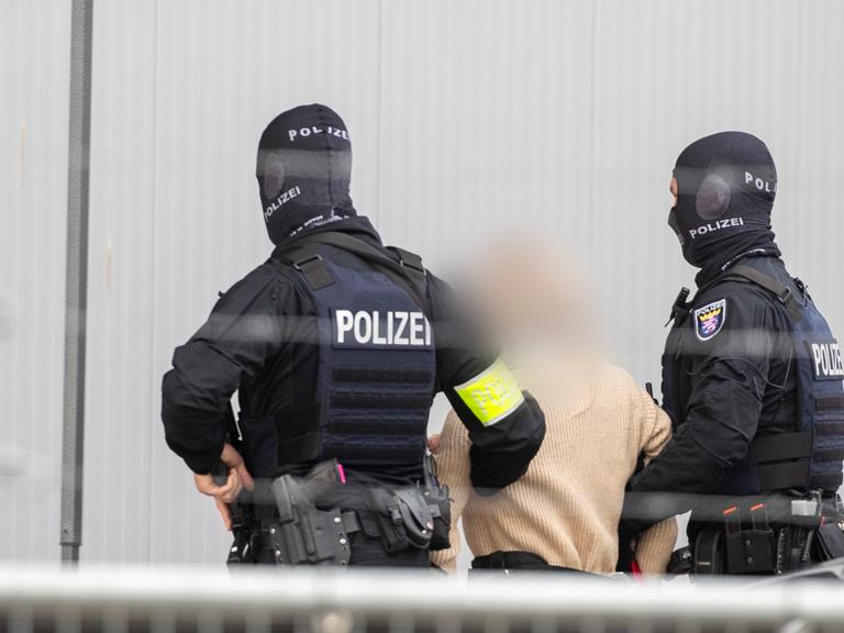 Frankfurt/Main: Polizei-Spezialeinsatzkräfte führen eine Angeklagte in das provisorische Gerichtsgebäude in der Außenstelle Sossenheim des Oberlandesgericht Frankfurt, in dem der Prozess gegen die mutmaßliche "Reichsbürger"-Gruppe um Prinz Reuß stattfindet