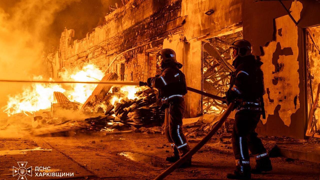 Zwei Feuerwehrmänner versuchen ein brennendes Haus zu löschen. Zwei Feuerwehrmänner versuchen ein brennendes Haus zu löschen.