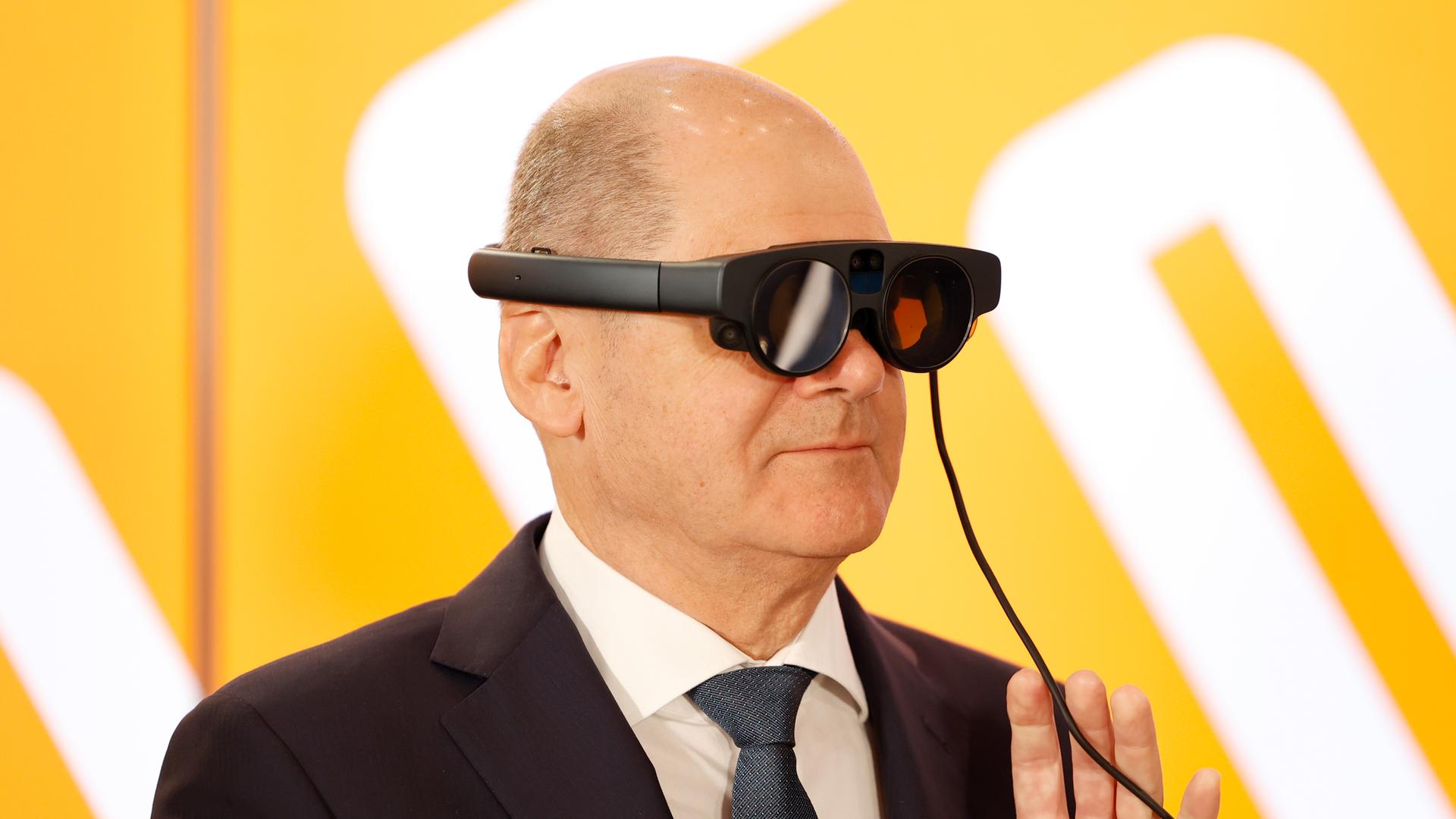 Bundeskanzler Olaf Scholz (SPD) trägt beim Eröffnungsrundgang der Industriemesse Hannover Messe am Messestand von ifm electronic eine AR-Datenbrille (Augmented Reality) zur Prozessüberwachung von einer Maschine. 