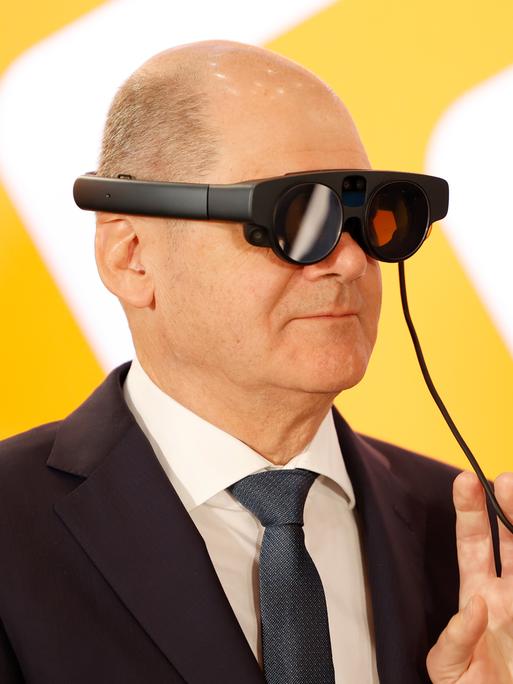 Bundeskanzler Olaf Scholz (SPD) trägt beim Eröffnungsrundgang der Industriemesse Hannover Messe am Messestand von ifm electronic eine AR-Datenbrille (Augmented Reality) zur Prozessüberwachung von einer Maschine. 
