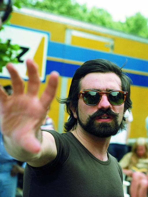 Martin Scorsese trägt eine Sonnenbrile und gibt Robert De Niro gestikulierend Regieanweisungen. Beide stehen im Freien.