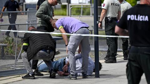 Der Mann liegt mit auf dem Rücken gefesselten Händen seitlich auf einem Bürgersteig. Um ihn herum mehrere uniformierte beziehungsweise in zivil gekleidete Polizisten.