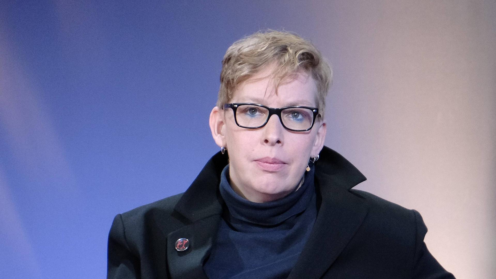 Die Schriftstellerin, Musikerin und Journalistin Manja Präkels sitzt auf dem blauem Sofa der Frankfurter Buchmesse.