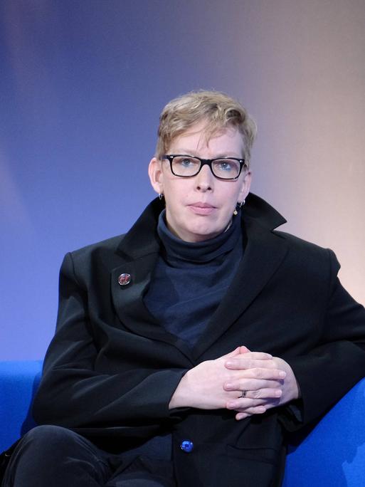 Die Schriftstellerin, Musikerin und Journalistin Manja Präkels sitzt auf dem blauem Sofa der Frankfurter Buchmesse.
