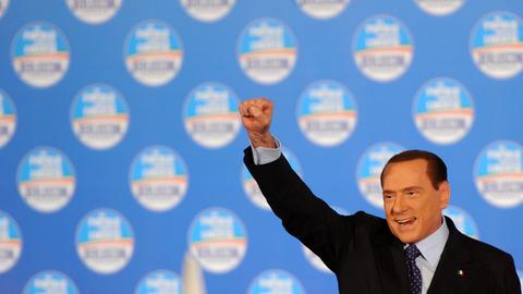 Silvio Berlusconi streckt bei einer Wahlkampfveranstaltung im Februar 2013 auf der Bühne die geballte rechte Faust nach oben.