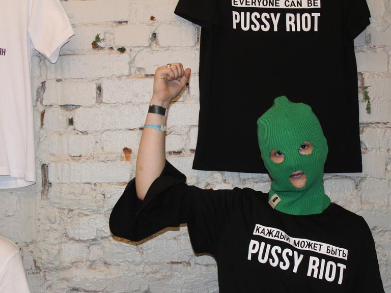 Ein Mitglied der russischen Punkrock-Band Pussy Riot posiert bei einem Benefiz-Konzert gegen häusliche Gewalt mit einem T-Shirt mit dem Ausdruck "Everyone can be Pussy Riot"