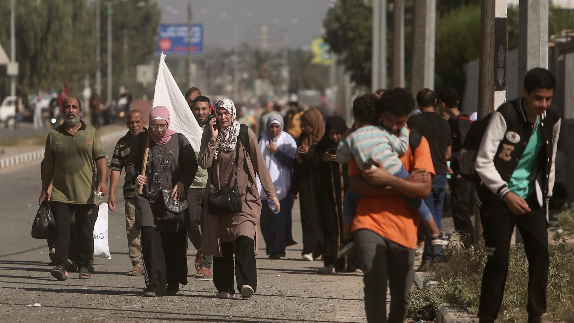 Palästinensische Gebiete, Bureij: Palästinenser fliehen mit einer weißen Fahne auf der Salah al-Din Straße aus Gaza-Stadt in den südlichen Gazastreifen. Palästinensische Gebiete, Bureij: Palästinenser fliehen mit einer weißen Fahne auf der Salah al-Din Straße aus Gaza-Stadt in den südlichen Gazastreifen.