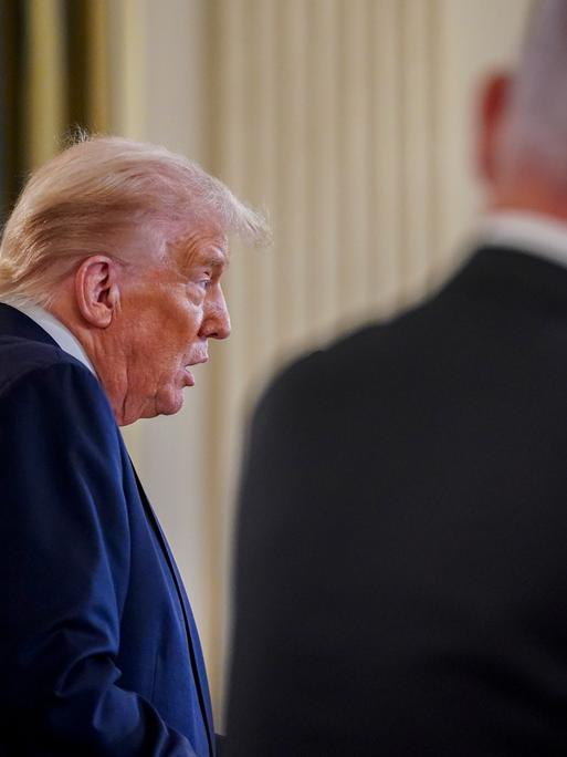 US-Präsident Donald Trump spricht im Weißen Haus. Neben ihm steht der israelische Ministerpräsident Benjamin Netanjahu. Es ist nur sein Rücken zu erkennen.