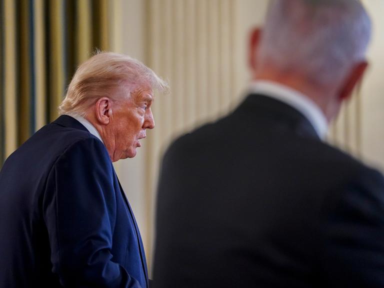 US-Präsident Donald Trump spricht im Weißen Haus. Neben ihm steht der israelische Ministerpräsident Benjamin Netanjahu. Es ist nur sein Rücken zu erkennen.