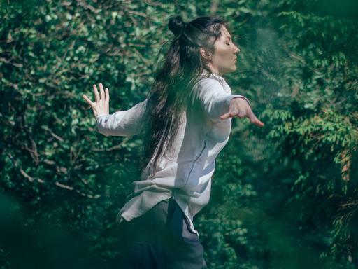 Tanzen - die Spannung zwischen Bei-sich-Sein und Außer-sich-Sein. Zu sehen: Eine Frau tanzt in einem Wald. 