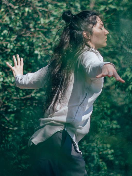 Tanzen - die Spannung zwischen Bei-sich-Sein und Außer-sich-Sein. Zu sehen: Eine Frau tanzt in einem Wald. 