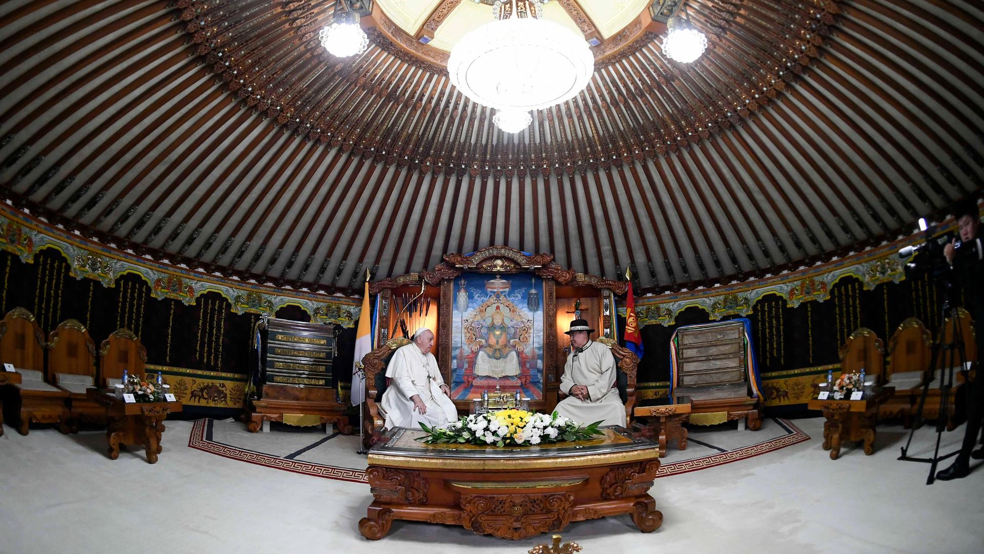 Papst Franziskus mit Staatspräsident Ukhnaagiin Khurelsukh in der Hauptstadt der Mongolei, Ulan Bator. Beide sitzen im Präsidentenpalast unter einer Kuppel an einem großen Holzschreibtisch. Papst Franziskus mit Staatspräsident Ukhnaagiin Khurelsukh in der Hauptstadt der Mongolei, Ulan Bator. Beide sitzen im Präsidentenpalast unter einer Kuppel an einem großen Holzschreibtisch.