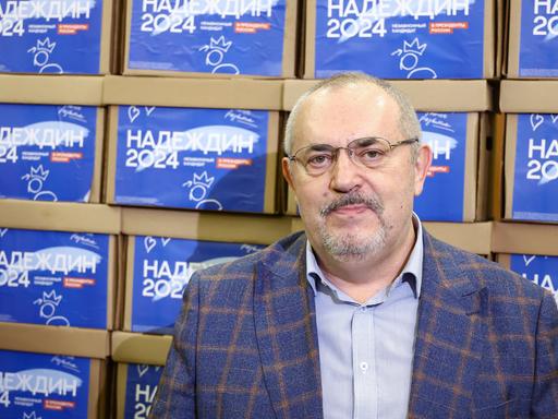 Boris Nadeschdin blickt in die Kamera. Im Hintergrund sind mehrere Logos seiner Kandidatur zu sehen. 