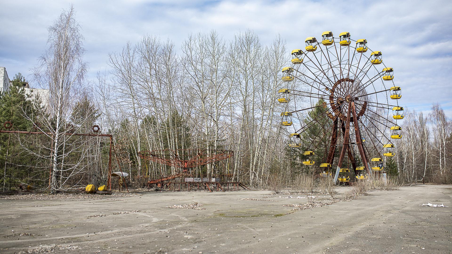Das verlassene und verfallene Riesenrad von Prypjat vor blauem Himmel mit weißen Wölkchen.