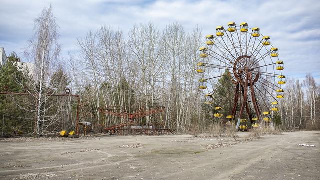 Das verlassene und verfallene Riesenrad von Prypjat vor blauem Himmel mit weißen Wölkchen.