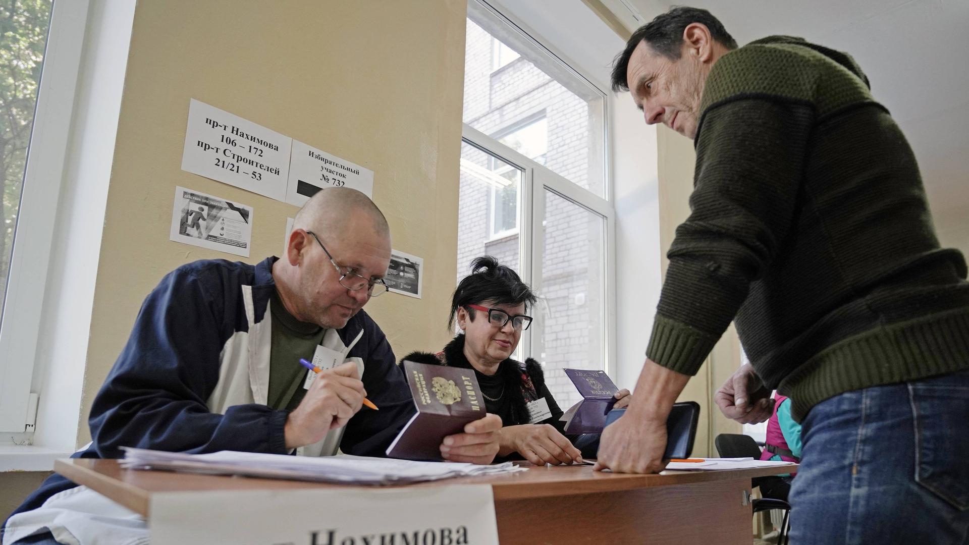 Ein Mann gibt in der von Russland besetzten ukrainischen Stadt Mariupol bei den Regionalwahlen seine Stimme ab. 
