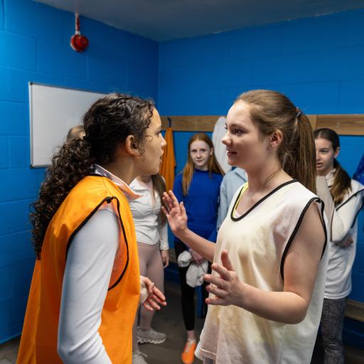 Konfliktlotsin: Mädchen in einer Schulumgebung neben Lockern, es sieht so aus, als hätte es einen Streit gegeben, ein Mädchen versucht, zu schlichten