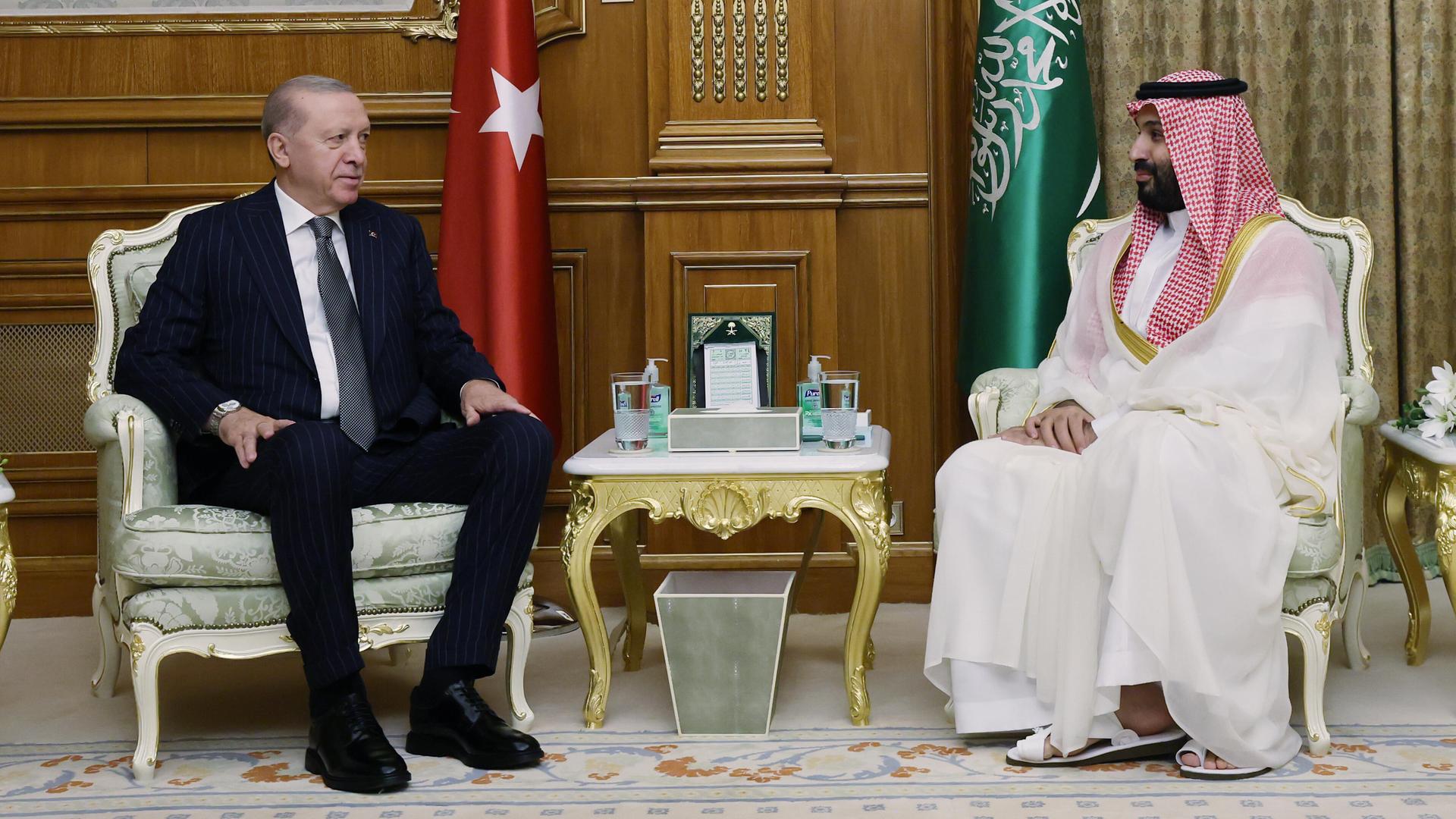 Erdogan und Prinz Mohammad bin Salman sitzen sich in Sesseln gegenüber, hinter ihnen die jeweiligen Landesfahnen.