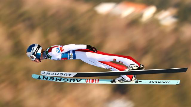 Der Ski-Springer Daniel Tschofenig fliegt durch die Luft. Der Hintergrund ist verschwommen. 