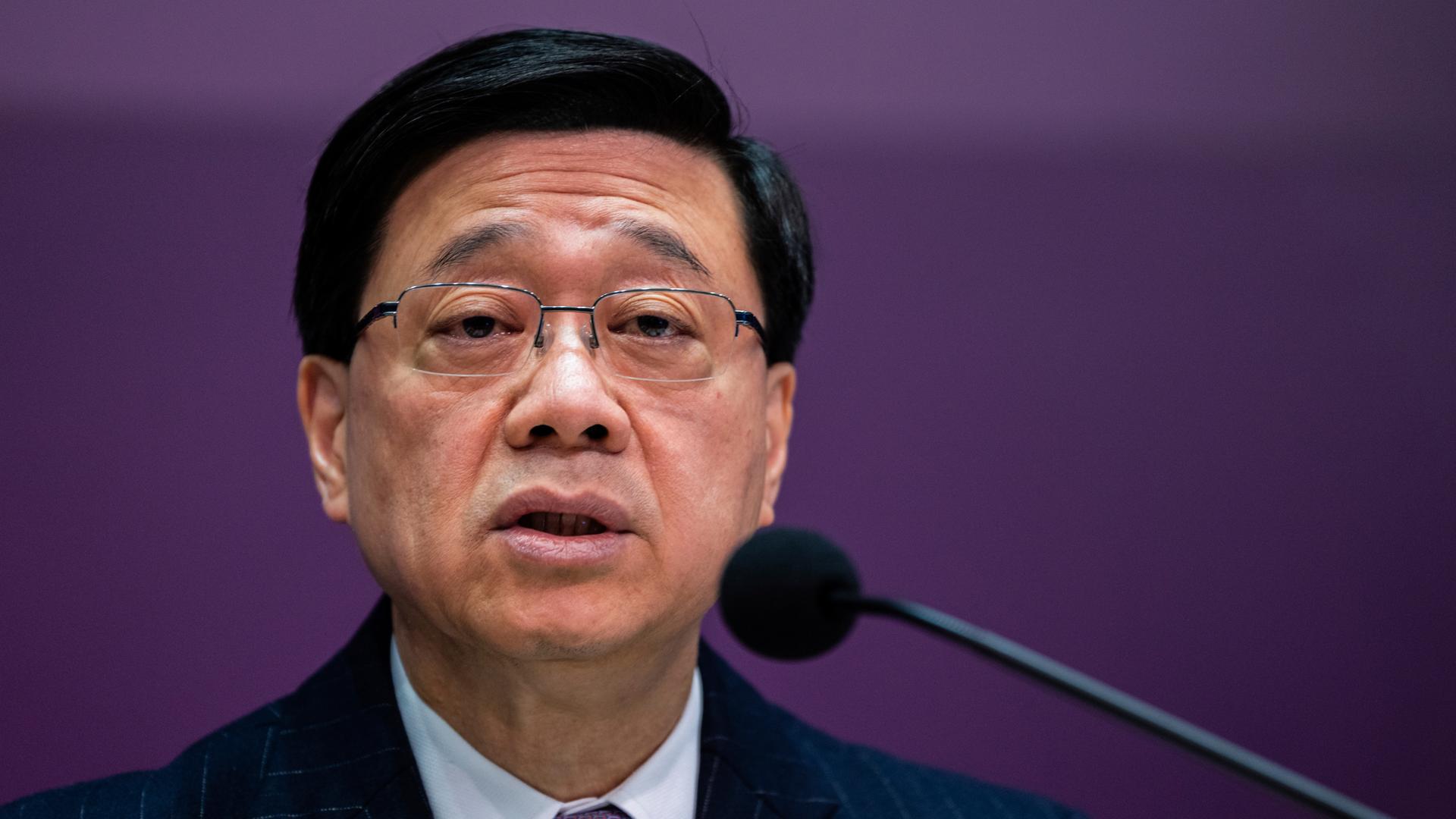 Hongkongs Regierungschef John Lee spricht in ein Mikrofon. Hongkongs Regierungschef John Lee spricht in ein Mikrofon.