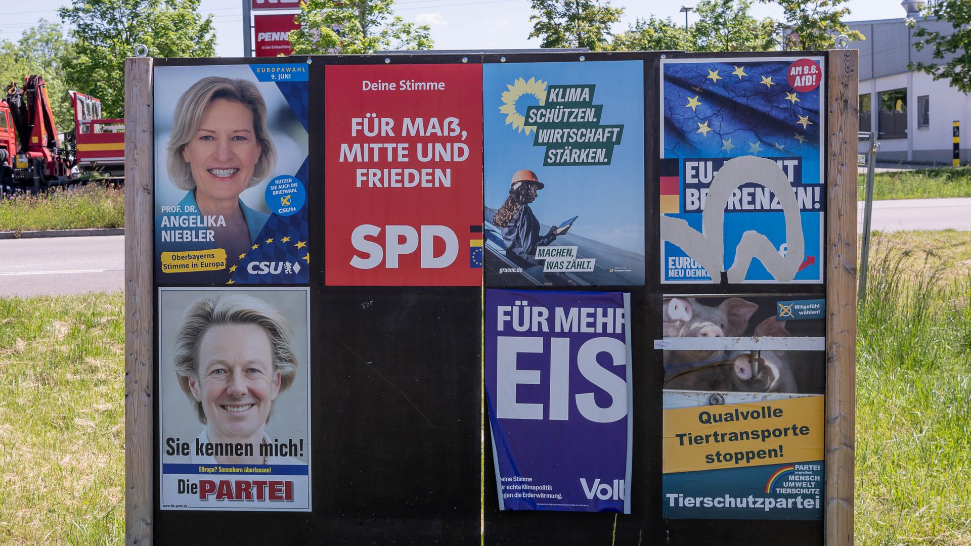 Eine Plakatwand zeigt Plakate verschiedener Parteien. In der ersten Reihe sind Plakate von großen Parteien wie CSU, SPD Grüne und AfD. In der zweiten Reihe sind Plakate von Kleinparteien zu sehen, darunter die Satirepartei, Volt und die Tierschutzpartei.