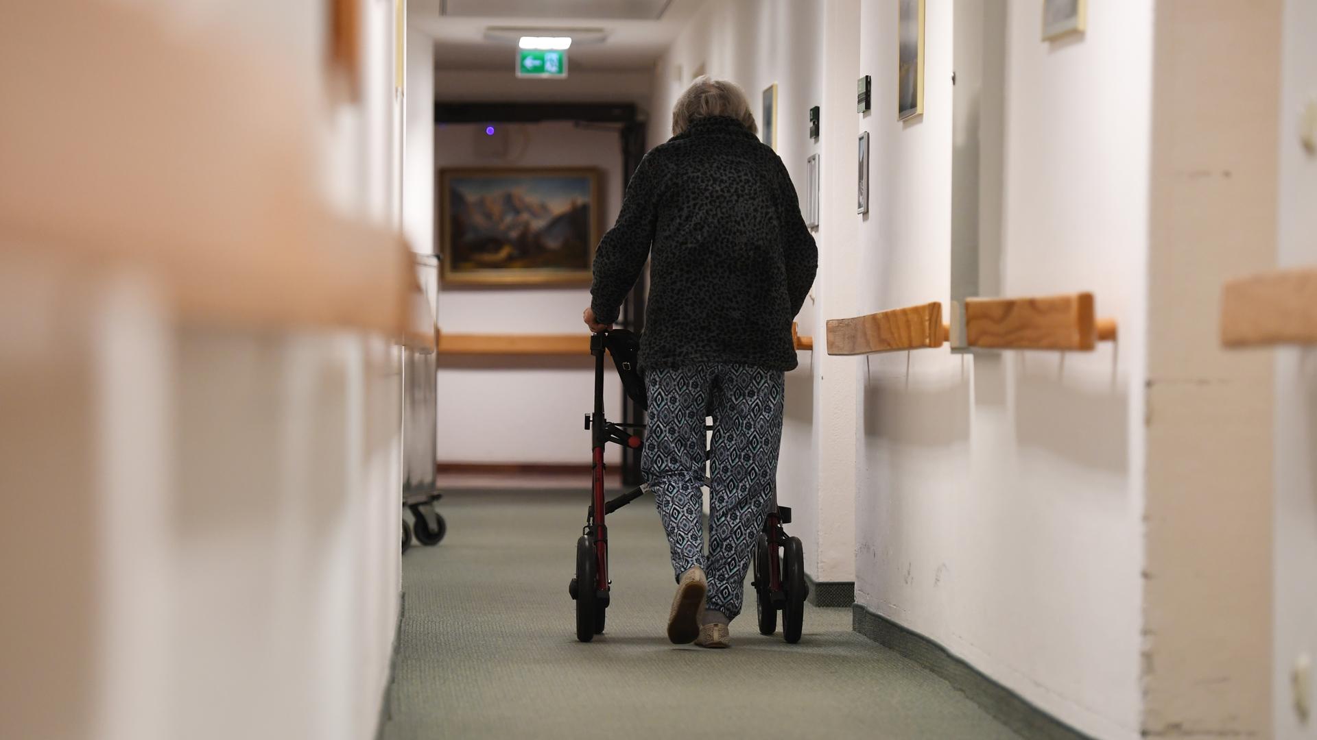 Eine Heimbewohnerin schiebt ihren Rollator durch einen Gang in einem Altersheim. Eine Impfpflicht für Personal in Pflegeheimen bleibt umstritten.
